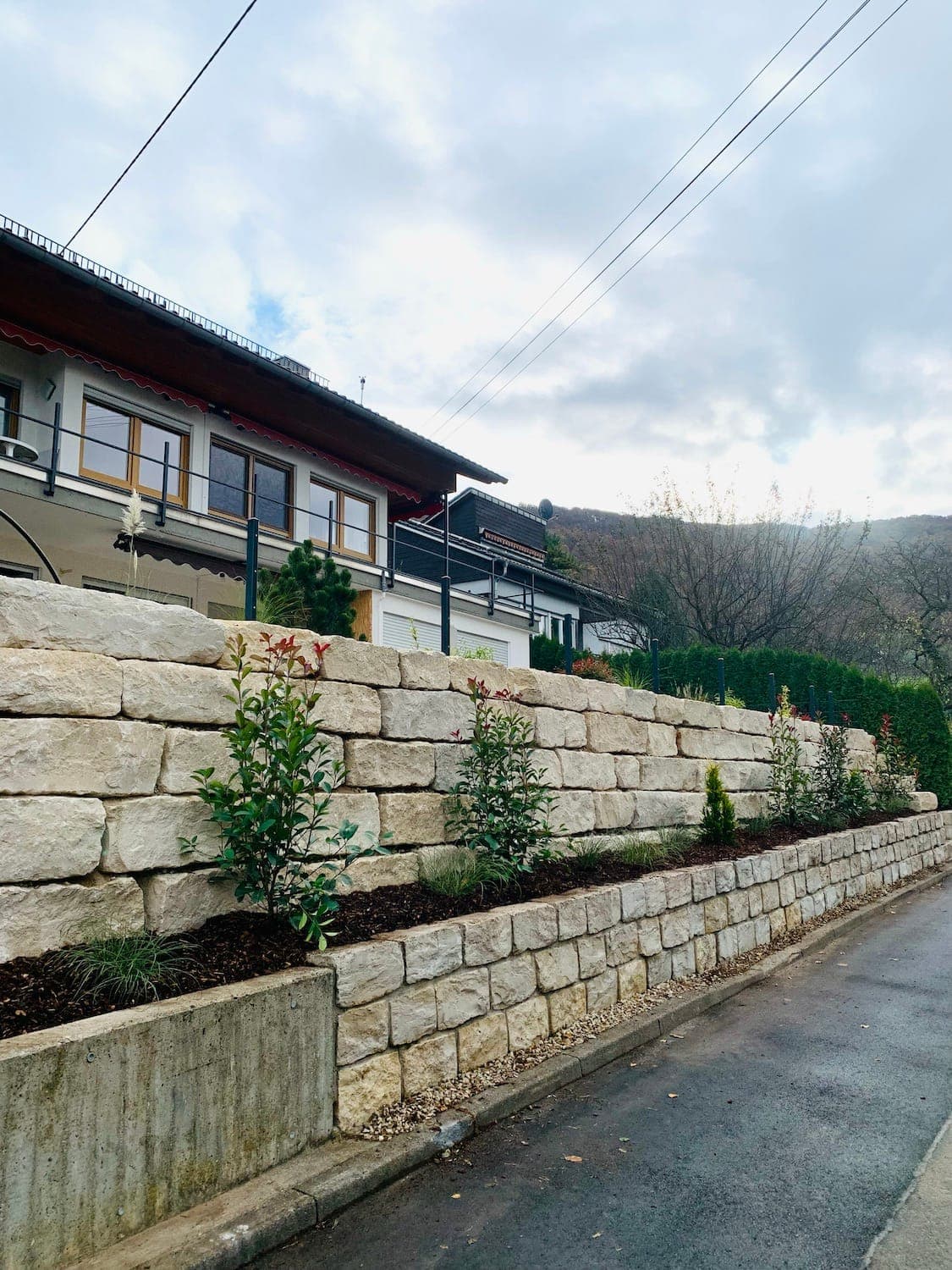 Erhöhte Terrasse mit Natursteinmauer im Garten